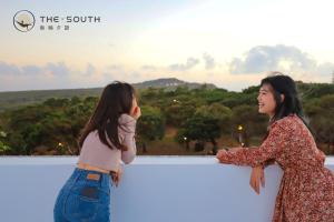 two girls standing on a ledge looking at the view at The South-Dawn in Hengchun