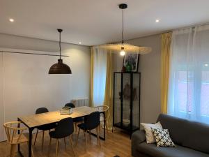 een woonkamer met een tafel en stoelen en een bank bij Amplio y moderno apartamento en Valladolid in Valladolid