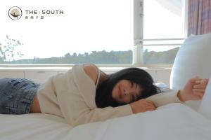 a woman laying on top of a bed at The South-Dawn in Hengchun