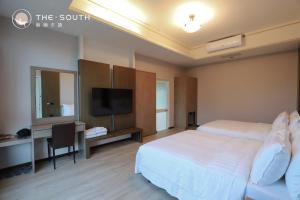 a hotel room with two beds and a flat screen tv at The South-Dawn in Hengchun