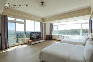 a hotel room with two beds and a large window at The South-Dawn in Hengchun