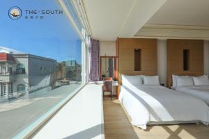 a bedroom with two beds and a large window at The South-Dawn in Hengchun