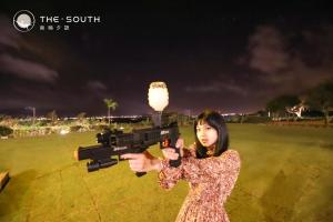 a woman holding a gun with a light on it at The South-Dawn in Hengchun