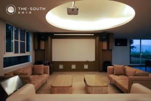 a living room with couches and a projection screen at The South-Dawn in Hengchun