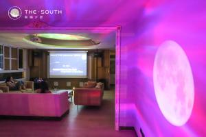 a room with a purple wall and a projection screen at The South-Dawn in Hengchun