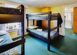 a bunk bed room with three bunk beds in it at HI Penticton - Hostel in Penticton
