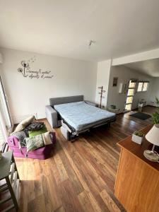 ein Wohnzimmer mit einem Bett und einer Couch in der Unterkunft Cottage entre Terre et Mer in Gouville-sur-Mer