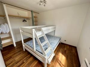 ein Schlafzimmer mit zwei Etagenbetten und Holzboden in der Unterkunft Cottage entre Terre et Mer in Gouville-sur-Mer