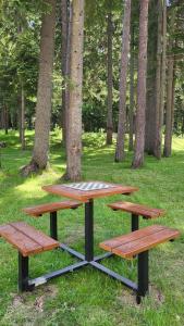 three picnic tables in a park with trees at MAGRI Luxurious Apartment A42 Borovets Gardens in Borovets