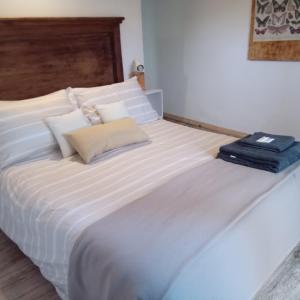 ein großes weißes Bett mit blauem Handtuch darauf in der Unterkunft El Olivo in Chacras de Coria