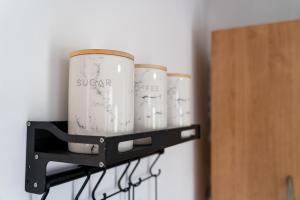 a shelf with four cups on a wall at Rare Hot Tub Town House with Free Parking Sleeps 6 in Braunstone