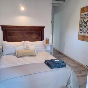 a bedroom with a large white bed with a wooden headboard at El Olivo in Chacras de Coria