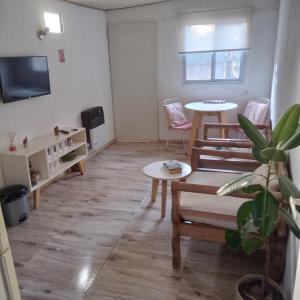 ein Wohnzimmer mit Tisch und Stühlen und einem Fernseher in der Unterkunft El Olivo in Chacras de Coria