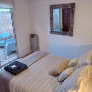 Schlafzimmer mit einem Bett und einem Spiegel an der Wand in der Unterkunft El Olivo in Chacras de Coria + 20 Fotos