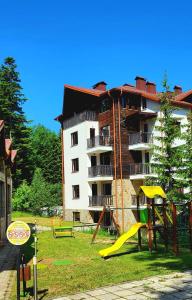a apartment building with a playground in front of it at MAGRI Luxurious Apartment A42 Borovets Gardens in Borovets