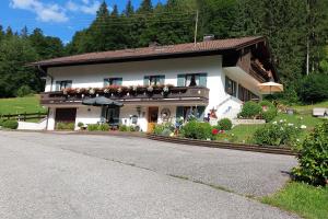 a large white house with flowers in front of it at Gästehaus Fellner in Aschau im Chiemgau