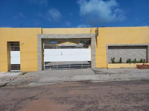 żółty budynek z dwoma dużymi drzwiami garażowymi w obiekcie Pousada Nordestino próx ATALAIA w mieście Salinópolis