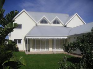 una casa blanca con techo gris en Waterside Living MM1394, en Jeffreys Bay
