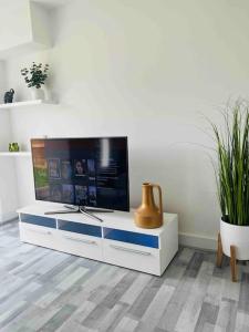 a living room with a tv on a white cabinet at Luxurious modern new built 4 bedrooms in Manchester