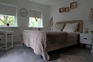 Schlafzimmer mit einem Bett, einem Tisch und einem Fenster in der Unterkunft Appartement Mooi Plekje Vlissingen in Vlissingen