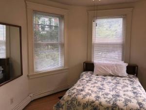 a bedroom with a bed and two windows at Walk to Downtown Salem in Salem