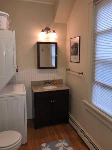 a bathroom with a sink and a toilet and a mirror at Walk to Downtown Salem in Salem