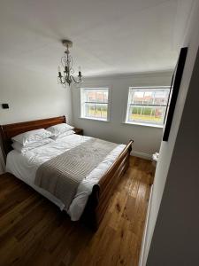 a bedroom with a large bed and two windows at Grammar School Yard in Hull