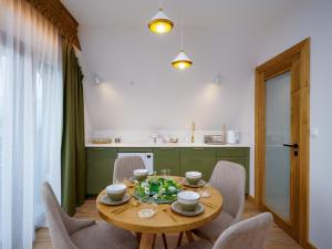 comedor con mesa de madera y sillas en Apartamenty Górski Prestige, en Białka Tatrzanska