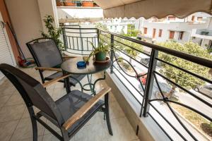 balkon ze stołem i krzesłami w obiekcie Central Cozy Apartment 2 w mieście Sparta