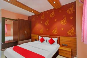 a bedroom with a bed with red and white pillows at Flagship Hotel Happy Stay in Surat