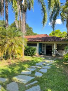 una casa con palmeras delante en Hotel Fazenda Tia Dora en Três Marias