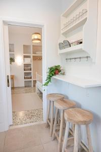 a kitchen with stools and a counter in a room at Sunny yard apartments in Poros