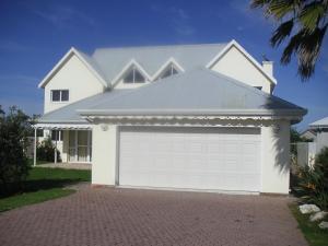 a white house with a white garage at Waterside Living MM1394 in Jeffreys Bay