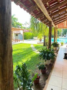 a patio with plants in a yard with a pool at Hotel Fazenda Tia Dora in Três Marias