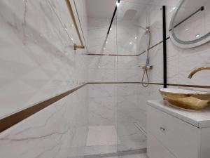 biała łazienka z umywalką i wanną w obiekcie Albatros Apartment Stogi w Gdańsku