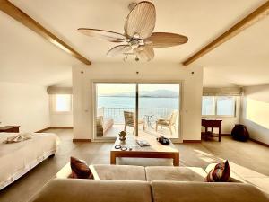a living room with a couch and a ceiling fan at Ece Hotel Sovalye Island in Fethiye
