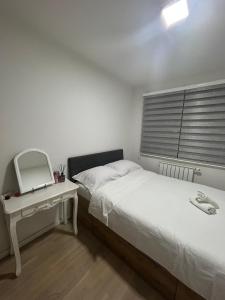 - une chambre avec un lit, un miroir et une table dans l'établissement Apartments Bulevar, à Sarajevo