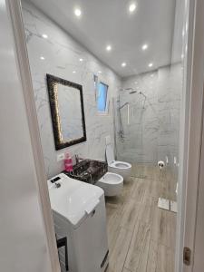 een witte badkamer met een wastafel en een toilet bij Vila 4G in Tirana