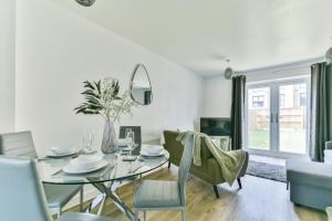 德比的住宿－Beautiful New House in Derby For up to 5 Guests, Suitable for Families Contractors NHS Staff etc，一间设有玻璃桌和椅子的用餐室