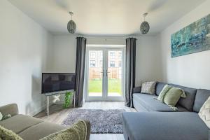 ein Wohnzimmer mit einem Sofa und einem TV in der Unterkunft Beautiful New House in Derby For up to 5 Guests, Suitable for Families Contractors NHS Staff etc in Derby