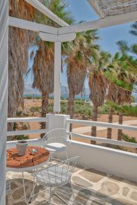 a table and chairs on a balcony with palm trees at Palm Heaven Boutique Apartments in Antiparos