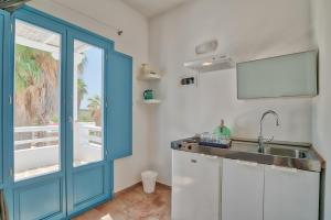 cocina con fregadero y puerta azul en Palm Heaven Boutique Apartments en Antiparos Town