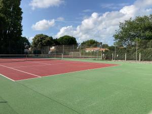 um campo de ténis com uma rede de ténis em Joli Studio em Grand-Village-Plage