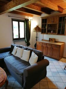 uma sala de estar com um sofá preto e uma cozinha em Casa Prucci em Battigio