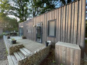 ein kleines Holzhaus mit einer Holzterrasse in der Unterkunft Chalet Het Edelhert in Zutendaal
