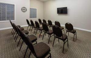 a group of chairs in a room with a tv at Grandstay Apple Valley in Apple Valley +16 photos