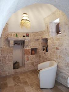 a bathroom with a tub and a stone wall at Holiday Home Trullo Antico in Ostuni