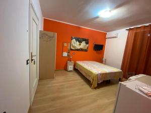 カステッランマーレ・デル・ゴルフォにあるCasa Vacanza Luigiのオレンジ色の壁の客室で、ベッド1台が備わります。