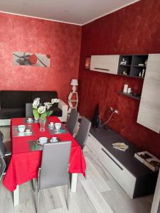 a red dining room with a table and chairs at Il giglio bianco in Ischia di Castro
