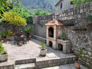 a stone patio with a fireplace in a stone wall at Summer Apartment in Kotor